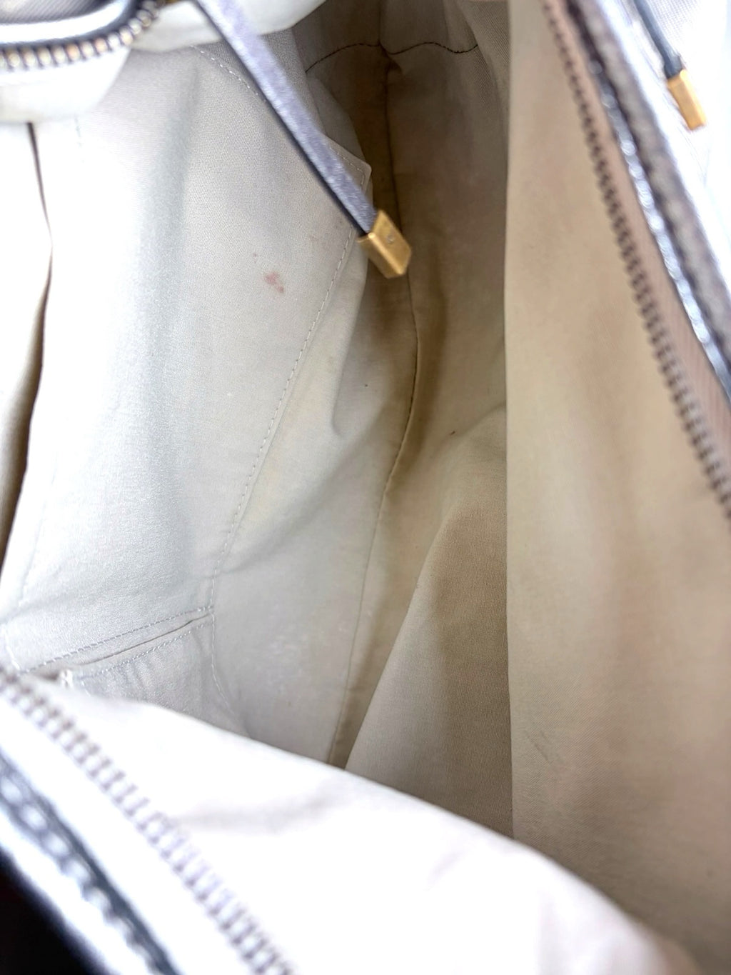 Interior of a Thrift Mint Louis Vuitton monogram canvas hobo bag featuring a light beige fabric lining and zipper.